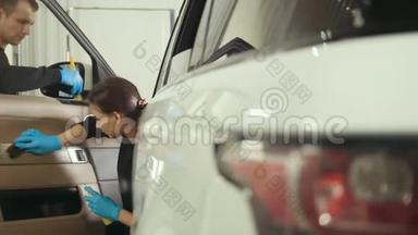 汽车细节-女人在豪华车上清洗仪表板